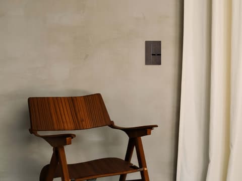 Silla de madera con reposabrazos en una casa con dómotica Barcelona y Girona